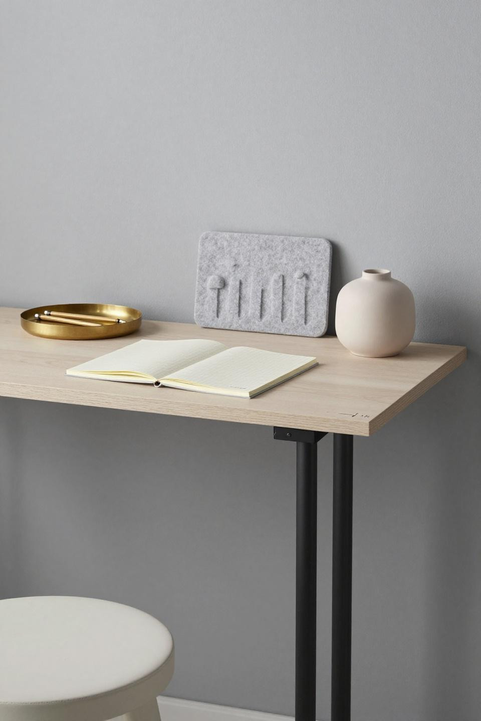 Minimalist workspace - pale ash standing desk on single steel post in urban alcove