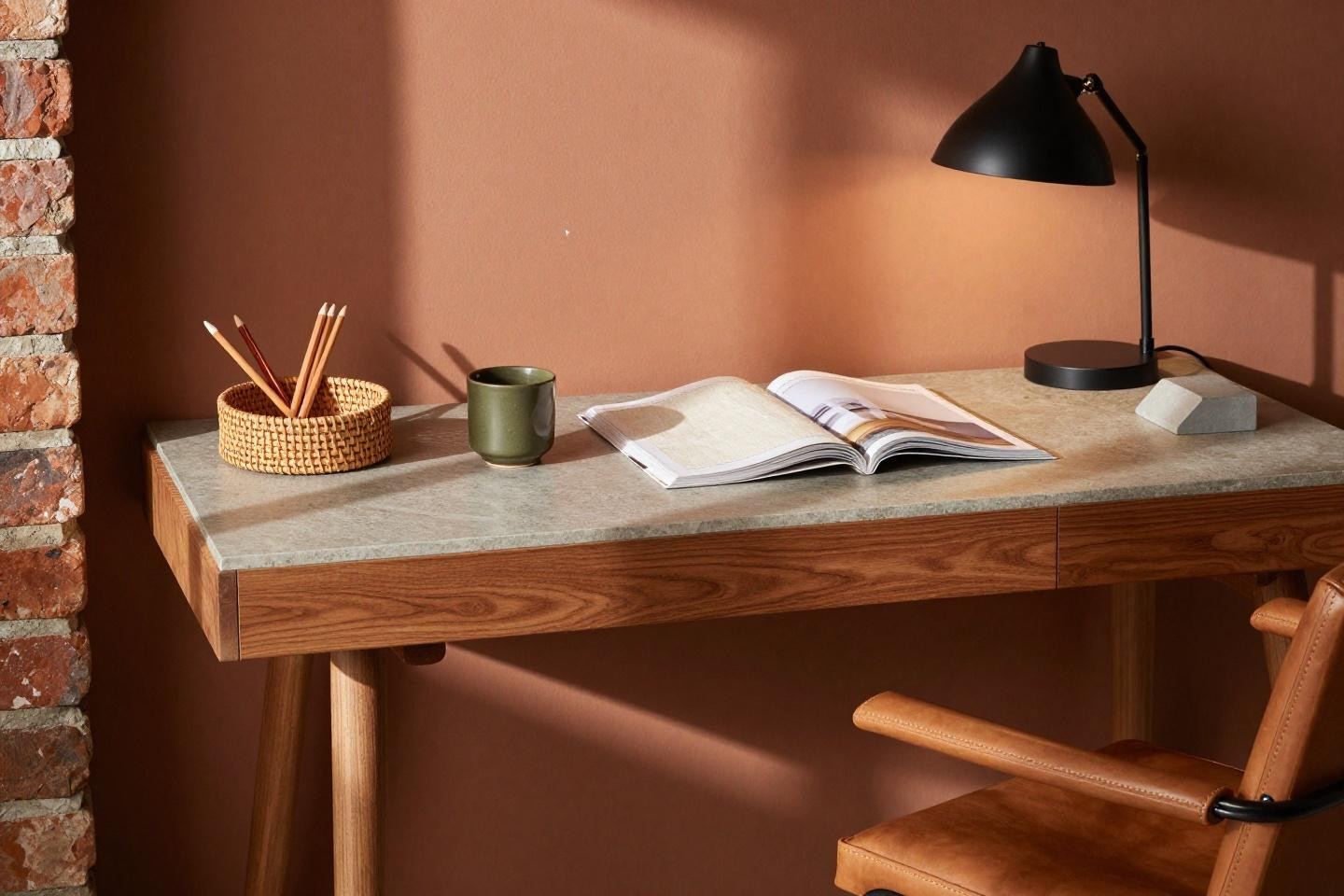 Wfh set up - walnut cantilever desk against terracotta accent wall with dramatic shadows