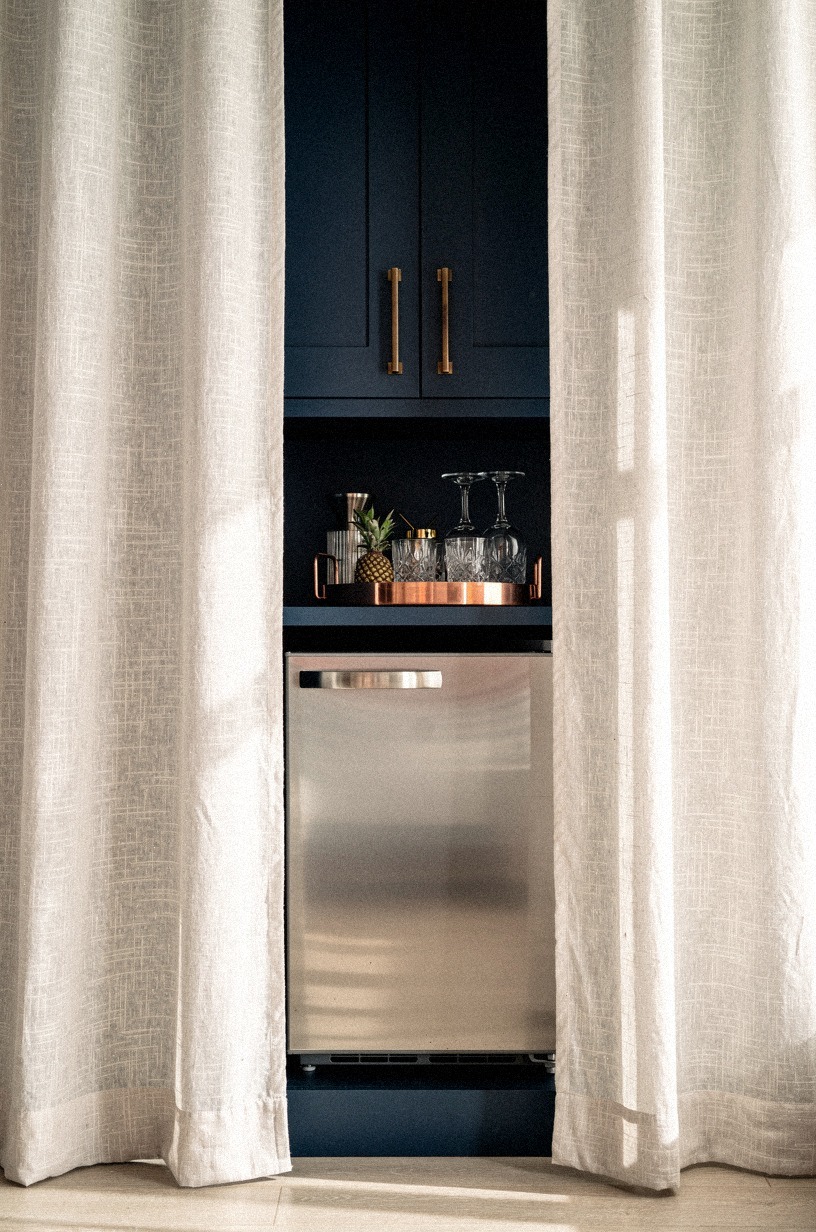 Tuck a mini fridge behind linen panels