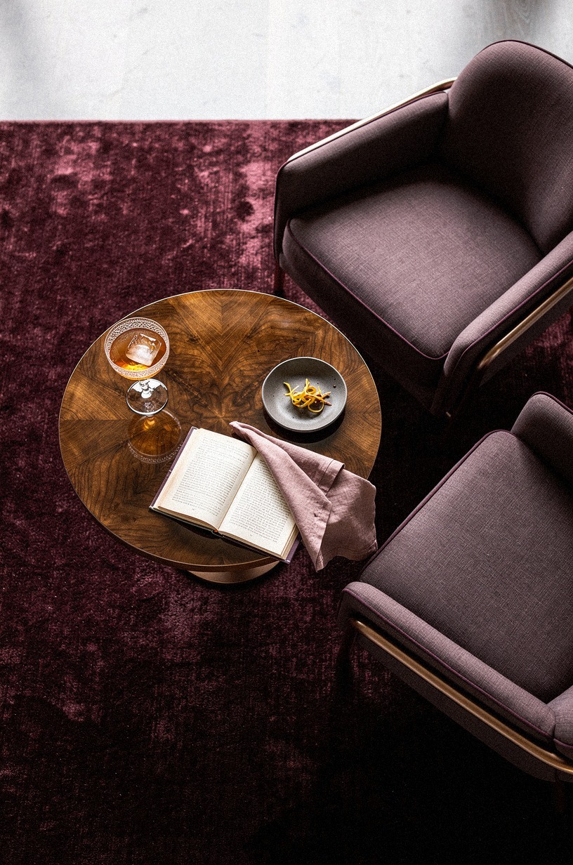 Layer a burgundy rug under club chairs