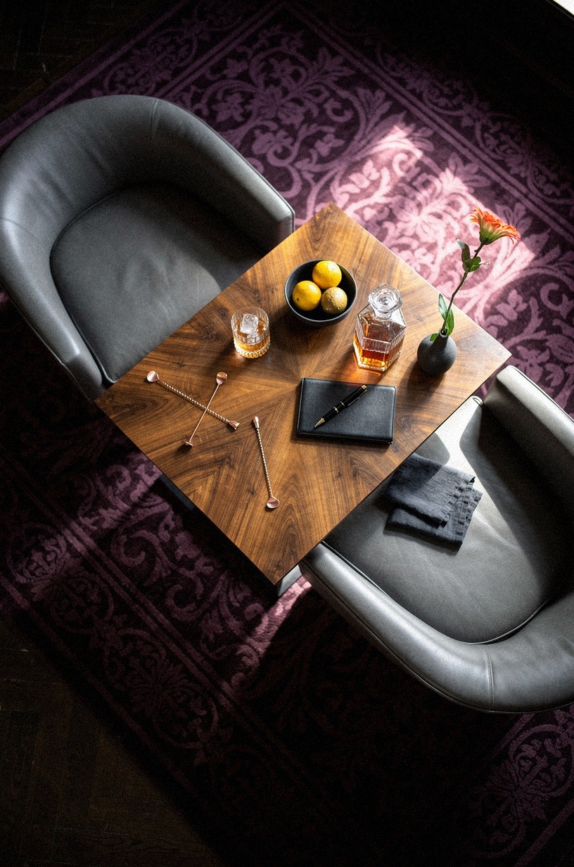 Layer damask rugs under leather chairs
