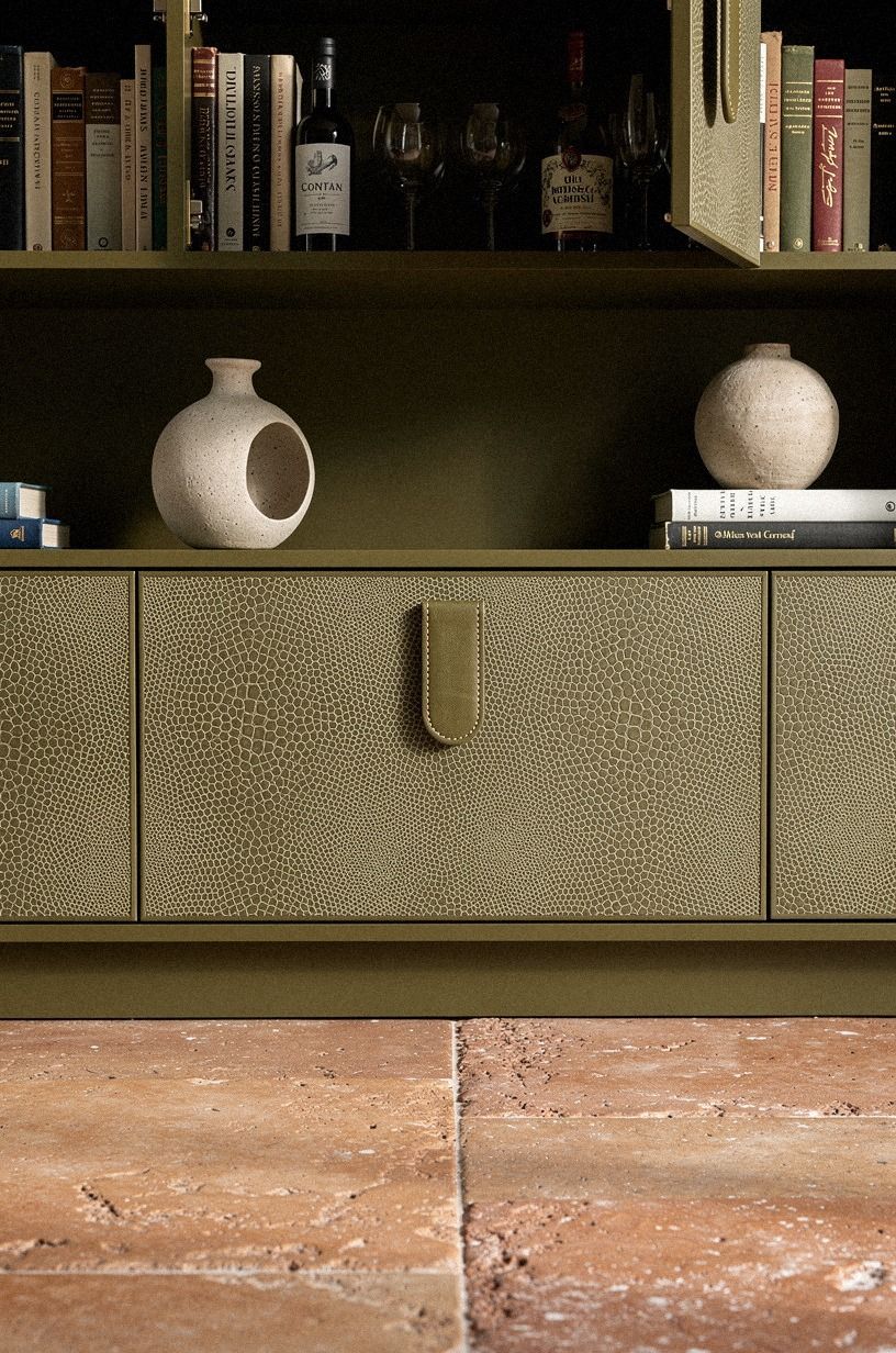 Stone bowl over faux books across cabinet doors