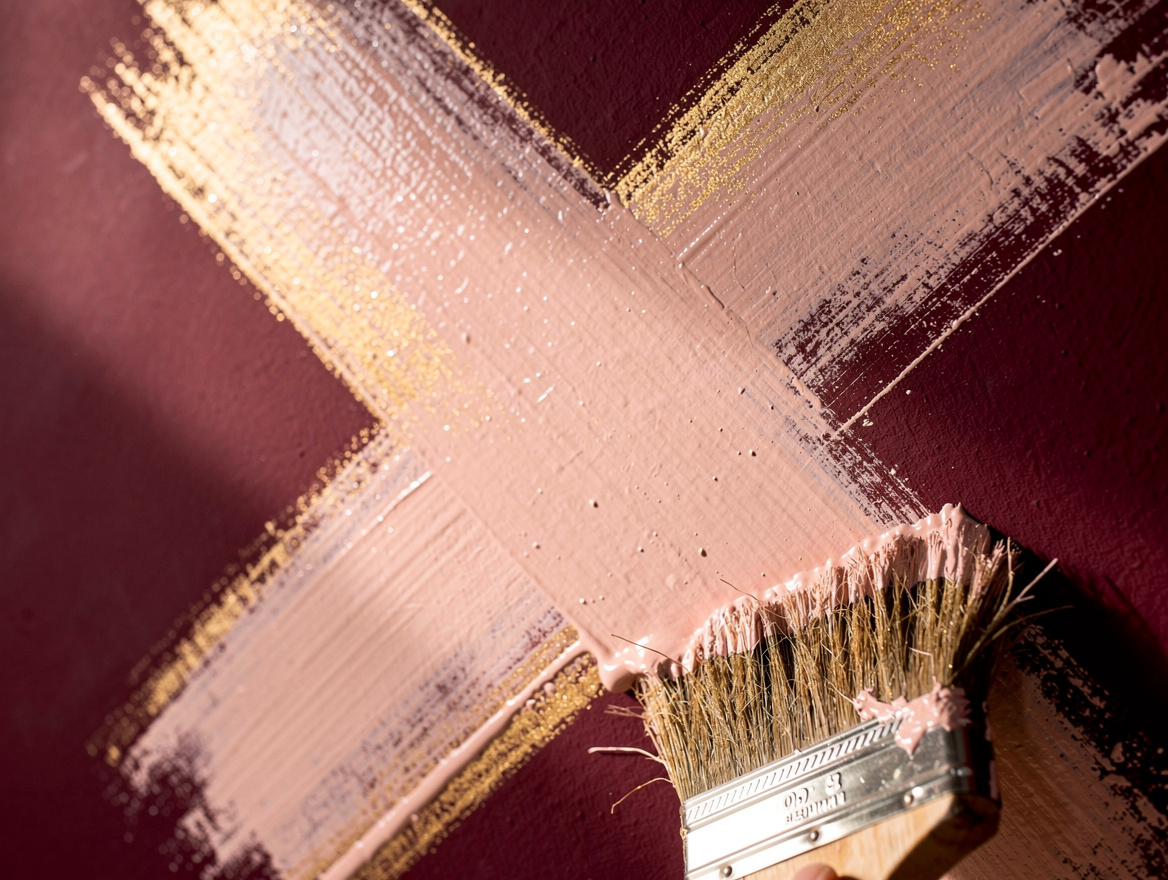 close-up detail of a large stiff-bristle block brush applying limewash paint in