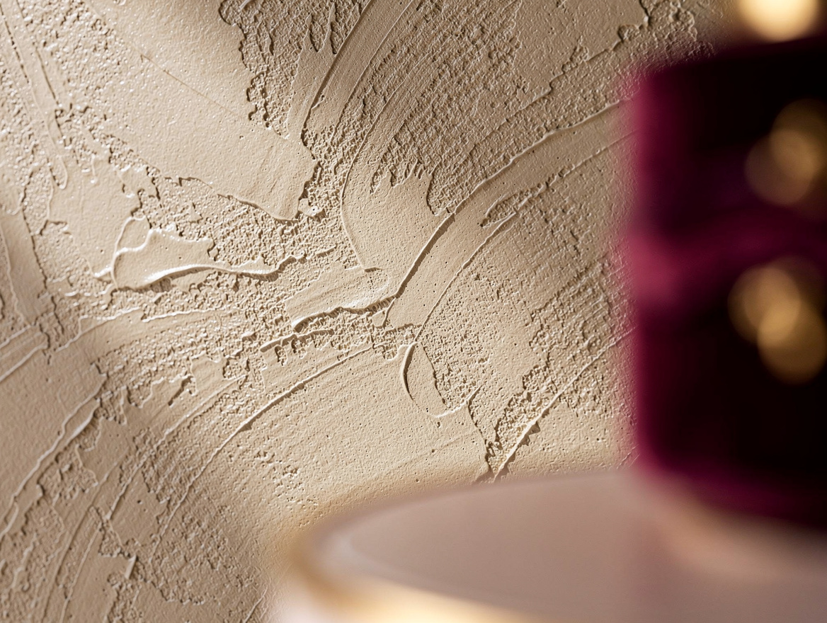 Close-up detail shot of a hand-troweled Venetian plaster wall showing layered te