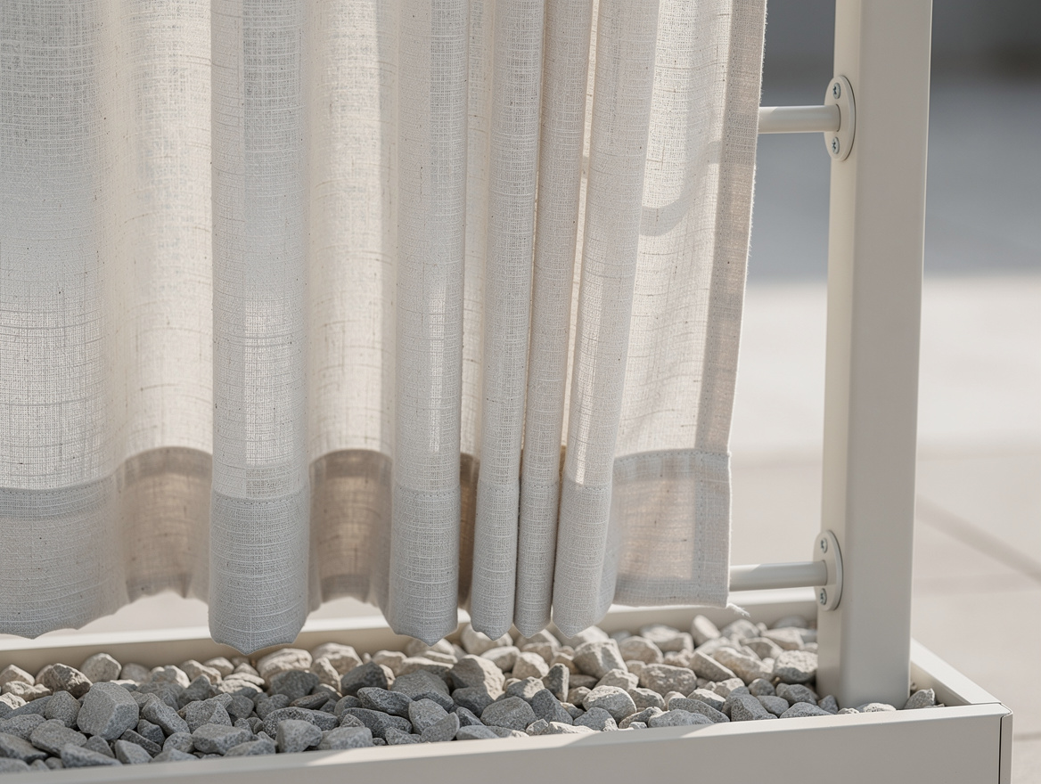 Close detail photo of weighted off-white outdoor curtains hanging from a painted