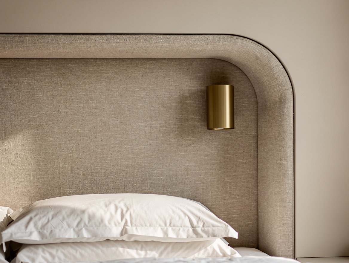 Realistic close-up photo of an alcove bed headboard with textured linen upholste