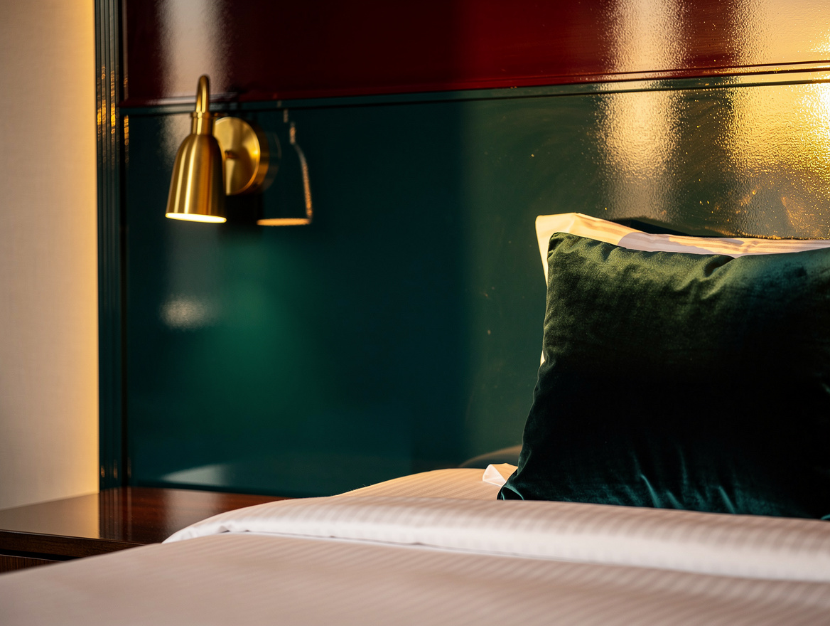 Close-up editorial detail of a high-gloss lacquered headboard panel with brass s