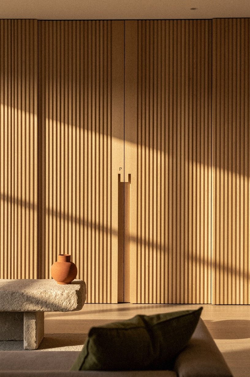 Track the door behind wall-to-wall slatted oak