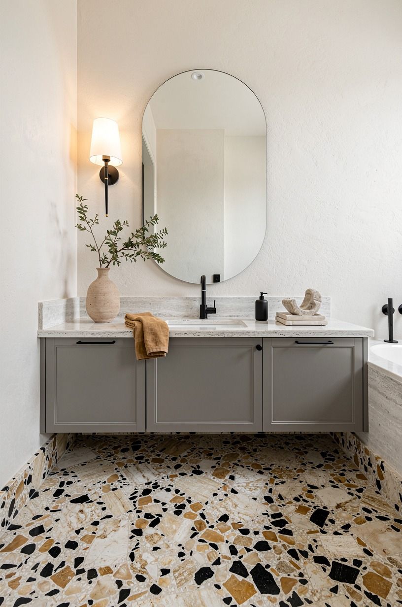 Float a rounded mirror above a gray travertine bathroom vanity