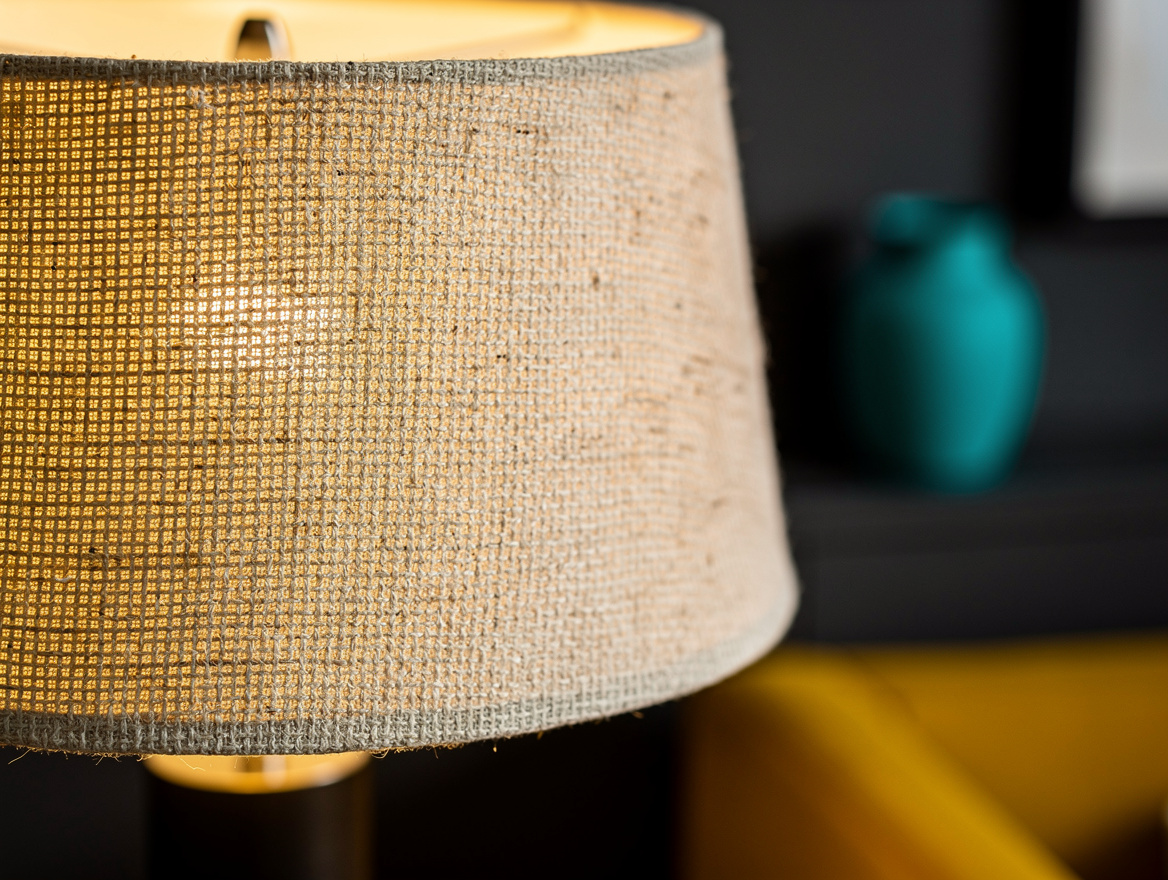 Close detail photo of an oatmeal linen lampshade showing its visible woven textu