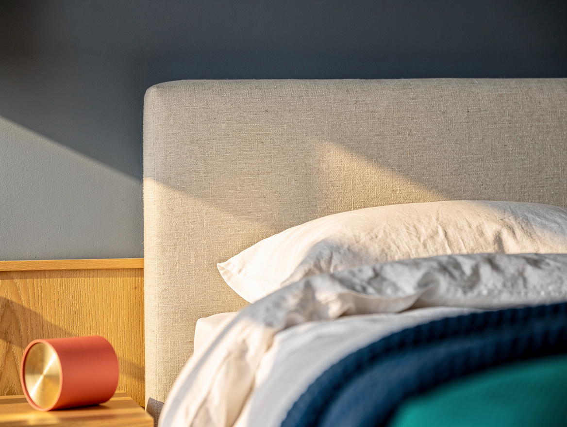 Realistic close-up detail of a muted blue-gray painted bedroom wall meeting an o