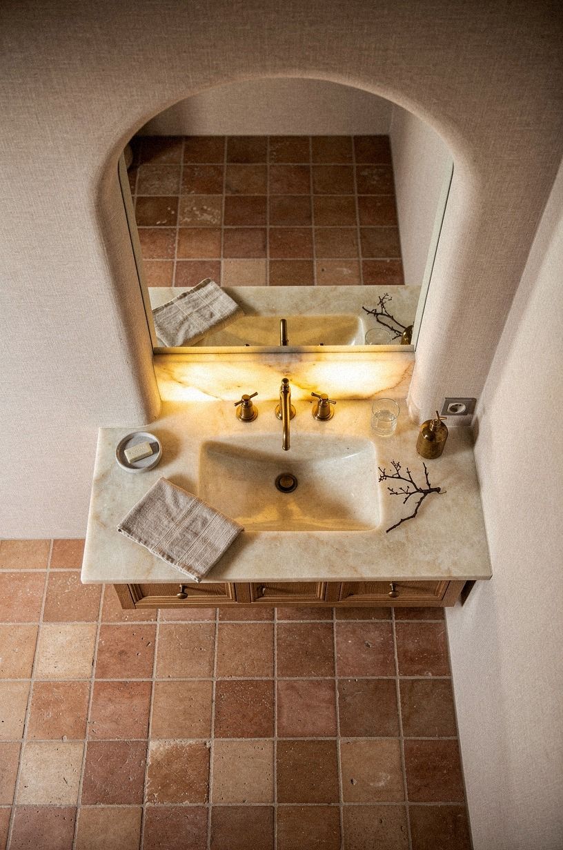 Frame the sink with a small Spanish style bathroom arch
