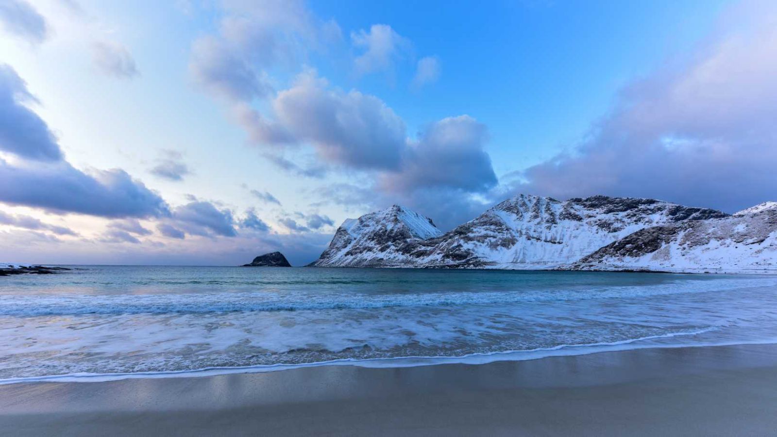 Sur cette plage, vous pourrez nager dans des eaux turquoise à l'ombre des montagnes enneigées