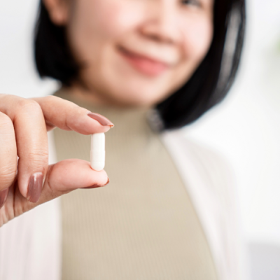 postbiotic femme qui prend une gelule