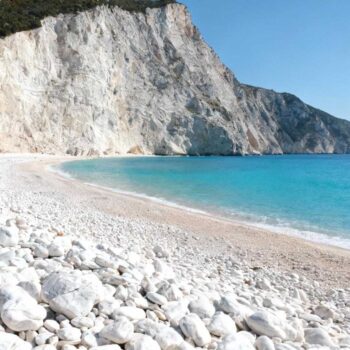 De gouden zonnestralen doorsnijden de ochtendnevel boven de Ionische Zee. Vanaf het uitzichtpunt zie je het onmogelijke: 800 meter wit kiezelstrand omgeven door 300 meter hoge kalksteenkliffen. Dit is Myrtos Beach op Kefalonia, 12 keer uitgeroepen tot beste strand van Griekenland. Maar hier komt de cruciale onthulling. Terwijl 200.000 bezoekers per jaar vechten om een plek in augustus, transformeert dit strand volledig in oktober. 75% minder drukte, accommodatie vanaf € 32 per nacht, en het turquoise water dat zijn volledige magie toont zonder mensenmassa's. Waarom Myrtos Beach elk ander Grieks strand visueel overtreft De geologische samenstelling vertelt het verhaal. Witte marmeren kiezels ontstaan door millennia van tectonische activiteit in de Pre-Apulian zone. Het turquoise water krijgt zijn kleur door mineraalreflecties van de omliggende kalksteenrotsen. GPS-coördinaten 38.2969°N, 20.4065°E brengen je naar de parkeerplaats bovenaan de klif. Vanaf Kefalonia luchthaven (EFL) rijd je 42 km via Argostoli in 55 minuten. De noordroute bespaart 13 minuten maar heeft smallere bergwegen. Anna Papadopoulos van Kefalonia Tourism Board benadrukt: "Myrtos Beach blijft Kefalonia's kroonjuweel vanwege het adembenemende turquoise water en ongerepte witte kiezels. Het trekt natuurliefhebbers elk jaar terug." Het geheim van oktober: wanneer komen bepaalt wat je ziet De transformatie begint na 15 september. Officiële cijfers tonen 750 dagelijkse bezoekers in oktober 2025 versus 3.100 in augustus. Het parkeerterrein met 98 plekken raakt nooit vol na september. Accommodatie prijsrevolutie in herfstmaanden Divarata village ligt 2,4 km van het strand. Olive Grove Studios kost € 32 per nacht in oktober versus € 100 in augustus. Amfitriti Hotel daalt van € 158 naar € 68 per nacht. Elena Papadakis, eigenaar van Olive Grove Studios, legt uit: "In oktober hebben we rust om met gasten te praten. Prijzen zijn 60% lager, maar we verdienen net zoveel omdat we het hele seizoen openblijven." Captain Corelli's filmlocatie impact De Hollywood-film uit 2001 verhoogde de bezoekersstroom van 18.000 naar 92.000 jaarlijks. Nicolas Cage's explosiescène werd gefilmd op het noordelijke strand bij coördinaten 38.2235°N, 20.5582°E. Yannis Laskaris, lokale gids sinds 2000, herinnert zich: "Voor 1999 kwamen er soms maar 20 toeristen per dag. De film bracht een revolutie voor ons eiland." Exacte kostenbreakdown: Myrtos Beach voor € 65 per dag Budgetoptimalisatie draait om timing en locatiekeuze. Oktober blijkt de geheime maand voor mediterrane bestemmingen. Eten zoals locals in Divarata tavernas Taverna "To Spitiko" serveert dagvangst vis voor € 18,50 versus € 27 in Argostoli. Verse sardellen kosten € 11 voor 6 stuks. Robola wijn, de lokale druif, kost € 3,80 per glas. Mandolato van lokale producent "Lithos Sweets" kost € 4,50 per kilo. Supermarkten in Divarata verkopen water voor € 1,20 versus € 3,50 bij strandbars. Vergelijkbare besparingen vind je langs de Ionische kust. Transport en toegankelijkheid Benzineprijs bedraagt € 1,95 per liter in oktober 2025. Huurauto's kosten € 34-48 per dag bij Kefalonia Wheels. De 243 treden naar het strand neem je in 6-8 minuten als volwassene. Parkeren blijft gratis sinds 2023. Het nieuwe uitzichtplatform "Pylaros View" opende in december 2024 met gratis toegang en toiletfaciliteiten. De route die toeristen missen: perfecte timing Watertemperatuur bereikt 22,4°C in oktober, ideaal voor zwemmen tussen 12:00-15:30. De populairste Instagram foto-tijd valt om 16:23 tijdens de "golden hour". Paul Dubois van National Geographic Traveler schrijft: "Myrtos Beach blijft in onze top Mediterrane strandlijsten vanwege zijn ongerepte karakter en dramatische landschap." Slimme timing bespaart aanzienlijke kosten op wereldwijde strandbestemmingen. Nieuwe strandregels voor 2025 verbieden verblijf na 19:00 uur en plastic flessen. Maximum 300 bezoekers tegelijkertijd via elektronisch tellingsysteem. Vodafone biedt de beste mobiele dekking bij de parkeerplaats. Jouw vragen over Myrtos Beach, Céphalonie (Grèce) beantwoord Wat is de beste maand zonder massa's? Oktober 2025 toont 75% minder bezoekers dan augustus. Temperaturen variëren tussen 16-22°C met 6,8 zonuren per dag. Shoulder season biedt dramatisch betere waarde voor kustbestemmingen. Hoe bereik je Myrtos vanuit Nederland? Amsterdam-Kefalonia duurt 2,5-4 uur directe vlucht voor € 150-350. Totale reistijd inclusief transfers: 6-8 uur. Vanaf de luchthaven rijd je 40 minuten naar het strand via huurauto. Waarom kiezen voor Myrtos boven Navagio Beach? Myrtos ontvangt 203.500 bezoekers per jaar versus 850.000 op Navagio. Waterhelderheid bereikt 28 meter diepte tegen 22 meter op Zakynthos. Autotoegang elimineert boottransfer van € 25 per persoon. De laatste zonnestralen kleuren de kalksteenkliffen oranje terwijl het turquoise water donker wordt. Mijn voetafdrukken blijven alleen achter in de witte kiezels. Dit is wat 200.000 andere bezoekers missen door in juli te komen.
