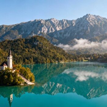 Om 07:30 's ochtends ligt Lake Bohinj in perfecte stilte. Mist danst boven kristalhelder water terwijl de 15e-eeuwse Sint-Johannes kerk baadt in gouden ochtendlicht. Geen toeristenbussen, geen wachtrijen, geen souvenirwinkels. Slechts 20 kilometer verderop wachten Lake Bled-bezoekers al in rijen voor het kasteel. Bohinj biedt dezelfde Alpenschoonheid met 70% minder bezoekers, €130 lagere accommodatiekosten en toegang tot ongerept Triglav Nationaal Park. Twee meren, twee werelden: de cijfers die het verschil maken Lake Bohinj ontvangt jaarlijks 300.000 bezoekers tegenover Bled's 1,2 miljoen toeristen. Deze cijfers vertellen het verhaal van twee verschillende benaderingen van Alpentoerisme. Accommodatieprijzen in Bohinj blijven €60-120 per nacht voor guesthouses. Bled vraagt €150-250 voor vergelijkbare verblijven in het hoogseizoen. Natuurlijke authenticiteit versus commercieel eiland Bohinj ligt volledig binnen Triglav Nationaal Park sinds 1924. Geen hotels staan direct aan het water. Het 4,1 kilometer lange meer behoudt zijn natuurlijke karakter zonder kunstmatige attracties. Bled daarentegen draait om het commerciële kasteel en kerkeiland. Pletna-boten varen constant tussen oever en eiland voor €25 per persoon. Prijsverschillen in dagelijkse uitgaven Een kom jota-soep kost €8-12 in Bohinj's lokale restaurants. Dezelfde maaltijd in Bled kost €18-25 door toeristenpremium. Kanoverhuur bedraagt €10 voor anderhalf uur in Bohinj. Bled-operators rekenen €22 voor dezelfde periode. Wat Lake Bohinj biedt dat Bled en Como vergaten Het meer strekt zich uit over 3,2 vierkante kilometer op 526 meter hoogte. Maximale diepte bereikt 45 meter met kristalhelder water dat tot de bodem zichtbaar blijft. Zoals Matej Košir, lokale gids, uitlegt: "Bohinj is het ultieme tegengif voor het toeristische spektakel rondom Bled. Hier vind je rust, natuur en authentieke beleving." Triglav Nationaal Park erfgoed De regio kent 2.500 jaar ijzerindustrie-geschiedenis. In de 16e eeuw brachten Laticiaanse smeden uit Friuli Venezia Giulia hun technieken naar Bohinj. De Sint-Johannes kerk dateert uit de 15e eeuw met fresco's en houtsnijwerk uit 1380. Geen toegangsprijs, geen verplichte souvenirwinkels bij de uitgang. Betaalbare kwaliteit versus luxeprijzen Panoramische boottochten kosten €15-20 per persoon in 2025. Lake Como vraagt €45-60 voor vergelijkbare excursies tussen Bellagio en Varenna. Eva Zupan, eigenaar van Guesthouse Ribčev Laz, bevestigt: "Onze gasten waarderen vooral de ongerepte natuur en stilte rond Lake Bohinj." Hoe je Lake Bohinj ontdekt: de insider-strategie Juni tot september biedt optimale omstandigheden met 22°C luchttemperatuur. Zwemwater bereikt aangename 22°C in juli en augustus. Vermijd winter met temperaturen van -2°C tot -7°C en mogelijke sneeuwbedekking rond het meer. Bereikbaarheid vanuit Nederland Ljubljana Airport ligt 45-60 minuten rijden van Bohinj. Vliegtickets Amsterdam-Ljubljana kosten €150-250 retour met 1,5-2 uur vluchtdijd. Autorit vanuit Amsterdam duurt 11-12 uur over 1.100 kilometer. Reken op €150-200 voor tol en brandstof enkele reis. Lokale ervaringen en gastronomie Verse forel komt rechtstreeks van lokale vissers naar restaurantkeukens. Traditionele jota combineert zuurkool met bonen en aardappelen voor €12-20 per portie. Honing en kruiden uit de Julische Alpen vormen populaire streekproducten. Ambachtelijke houtsnijwerkers werken nog volgens eeuwenoude traditie. De Lake Bohinj-ervaring die transformeert Terwijl Bled-toeristen selfies maken bij het kasteel, kanoën Bohinj-bezoekers tussen reflecties van 2.000 meter hoge Julische Alpen-toppen. Geen gedwongen fotostops, geen souvenirdruk. De nabijgelegen Savica-waterval valt 78 meter naar beneden zonder entreehekken of commerciële exploitatie. Locals vissen nog steeds forel voor hun eigen restaurants. Dit authentieke Alpenmeer-geheim koesteren Bohinj's 5.000 inwoners: schoonheid zonder performance, natuur zonder decoratie. Wandelpaden leiden rechtstreeks Triglav Nationaal Park in. Jouw vragen over Lake Bohinj, Slovenië – rustiger dan Bled beantwoord Is Lake Bohinj makkelijk bereikbaar vanuit Nederland? Directe vluchten Amsterdam-Ljubljana duren 1,5-2 uur voor €150-250 retour. Van Ljubljana Airport rijdt u 45-60 minuten naar Bohinj via taxi of huurauto voor €60-80. Alternatief: auto vanuit Nederland via Duitse en Oostenrijkse routes in 11-12 uur. Geen rechtstreekse treinverbinding, maar Bohinjska Bistrica station ligt enkele kilometers van het meer. Wat zijn de echte kosten voor drie dagen Lake Bohinj? Accommodatie: €180-360 voor guesthouse midden-segment. Maaltijden: €72-135 bij lokale restaurants. Activiteiten: €30-50 inclusief kano, boottocht en wandelen. Totaalbudget: €282-545 voor drie dagen. Dit bedrag dekt slechts één-twee nachten in Lake Bled tijdens hoogseizoen. Hoe verschilt Lake Bohinj echt van Lake Bled? Bohinj ontvangt 300.000 bezoekers jaarlijks zonder commercieel eiland of kasteel. Triglav Nationaal Park beschermt 4,1 kilometer natuurlijke kustlijn met prijzen 15-25% onder Bled-niveau. Bled trekt 1,2 miljoen bezoekers naar kasteel en kerkeiland. Meer urbanisatie, hogere horeca-prijzen, intensieve toeristische marketing. Bohinj voelt als ongerept natuurreservaat. Ochtendmist lost op boven Lake Bohinj terwijl een solo-kanoër gleed door spiegelgladde reflecties. Alleen peddels door 45 meter diep kristalwater – de Alpenmeer-ervaring die Bled vergat te beschermen.