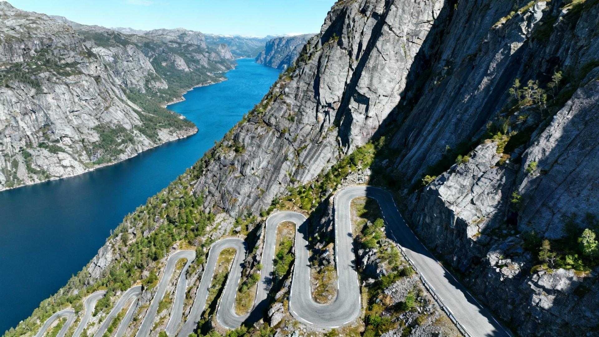 Wanneer de 340-graden haarspeldBocht van de Lysetunnel zich opent, verschijnt 1.000 meter beneden je de azuurblauwe Lysefjord. Je bent net acht van de 27 legendarische haarspeldbochten gepasseerd. Lysebotn wacht beneden, het rustige eindpunt van Noorwegens meest spectaculaire bergweg. Terwijl cruise-passagiers € 180 betalen voor een 3-uur pakket met vaste schema's, ontdek je de Lysevegen op eigen tempo voor € 120 per dag. Complete controle over timing, stops en de 5 viewpoints die bussen missen. Van Amsterdam naar Lysebotn: de 1.250 km strategie De reis van 1.250 km vanaf Amsterdam vereist strategische planning. Drie hoofdroutes leiden naar Lysebotn: directe autoroute via Stavanger (15 uur rijden), veerboot-combinatie via Forsand (13 uur inclusief 2u20m boottocht), of vlieg-plus-huur via Stavanger Airport. De cruciale factor: de Lysevegen opent seizoensgebonden eind mei en sluit in november bij sneeuwval. GPS-coördinaten 58.9547°N, 6.5940°E markeren je eindbestemming. In wintermaanden bereik je Lysebotn uitsluitend per veerboot vanuit Forsand. Net als de Flåmsbana vereist timing alles. Plan aankomst tussen 26 mei en 28 oktober voor gegarandeerde wegtoegang. Timing en kosten: het mei-september venster Slimme timing levert € 155 accommodatiebesparing op. Mei-accommodaties kosten € 80-120 in guesthouses, augustus-prijzen schieten naar € 150-250 door cruise-invasie. De sweet spot: laatste week mei wanneer sneeuwwanden nog 3-4 meter hoog staan maar de weg net open is. Dagelijkse kosten breakdown Transparante budgettering: accommodatie € 95-165 (Lysebotn Fjellstue), maaltijden € 22-35 (Lysefjorden Kafé), veerboot € 15-40 afhankelijk van route. Totaal € 120-185 per dag voor authentieke meerdag-ervaring. Vergelijk dit met € 180 cruise-pakket met 3-uur tijdslimiet. Zelfstandig betekent overnachting tussen de 120 inwoners, ochtendroutine observeren, verse vis kopen bij lokale vissers om 07:00. Verkeersstrategie per seizoen Mei: 200-300 voertuigen per dag, rustigste maand. Augustus: 800-900 voertuigen, drukte tussen 08:00-19:00. Vergelijkbaar met het 250-zielen dorp Å, vermijd weekends in juli-augustus. De 27 haarspeldbochten navigeren: 5 essentiële stops De Lysevegen-ervaring transformeert een technische rit in bergontdekking. 20 kilometer traject, 932 meter hoogteverschil, gemiddelde rijtijd 1u15m. Gebruik lage versnelling bij afdaling, vooral bij de onderste 10 bochten waar bussen moeite hebben. Startpunt Sirdal tot Lysetunnel Het laatste tankstation bevindt zich in Ålgård, 45 km voor Lysebotn (€ 1,75/liter). De iconische Lysetunnel met 340-graden bocht biedt het eerste adembenemende fjord-panorama. Fotomoment gegarandeerd, verkeersdrukte tip: arriveer vóór 10:00 of na 16:00. Nieuwe viewpoint "Råså Vista" opent juli 2025 bij de tunnel. 20 extra parkeerplaatsen bij Øygardstøl voor wie de 2 km wandeling naar Kjeragbolten-trailhead wil maken. Lokale ervaringen: Kjeragbolten toegang Lysebotn fungeert als basecamp voor de 6 km wandeling naar Kjeragbolten op 1.084 meter hoogte. Gratis toegang tot de beroemde rots tussen twee kliffen. Net als in de Alpen geldt timing: vroege ochtend voor lege routes. "Kom voor 09:00 aan als je rustig wilt rijden. Na 11:00 wordt het druk met bussen," legt Ole Hansen uit, inwoner van Lysebotn sinds 1998 en eigenaar van Lysebotn Fjellstue. Wat cruise-toeristen missen: de lokale Lysebotn-ervaring Cruise-bezoekers krijgen 3 uur. Zelfstandige reizigers ontdekken de Lysegården boerderij, kopen verse zeebaars direct van vissers (€ 22/kg, beste tijd 07:00-09:00), proeven gjetost (bruine kaas) voor € 8/200g. De Lysefjord Waterkrachtcentrale uit 1985 biedt rondleidingen op aanvraag (minimum 10 personen). Interactieve tentoonstelling toont hoe 1.200 GWh per jaar wordt opgewekt. Net als de Bodensee-route onthult mei-september de beste lokale ervaring. "De beste tijd voor verse vis is tussen 07:00 en 09:00, wanneer vissers terugkeren. Vraag naar 'fisk fra morgon' voor versheidsgarantie," vertelt Elin Berg, visser in Lysebotn sinds 2005. Jouw vragen over Lysebotn, Noorwegen – eindpunt van een epische weg beantwoord Is de Lysevegen gevaarlijk voor onervaren bestuurders? 27 haarspeldbochten vereisen focus maar geen speciale vaardigheden. Weg goed onderhouden, verkeer gematigd buiten juli-augustus. Belangrijkste tip: rem op motor in lage versnelling bij afdaling. Moeilijkheidsgraad 7/10, vergelijkbaar met Transfăgărășan. Wat zijn de lokale specialiteiten in Lysebotn? Verse zalm en kabeljauw rechtstreeks van vissers, rendiergerechten (€ 32/maaltijd, seizoensgebonden oktober-mei), bruine kaas gjetost gemaakt met geitenmelk. Eén restaurant/café, dus zelf-catering voor avonden praktisch. Inkopen in Stavanger voor aankomst. Hoe verhoudt Lysevegen zich tot Trollstigen? Lysevegen: 27 haarspeldbochten vs Trollstigen's 11, 185.000 jaarlijkse bezoekers vs Trollstigen's 650.000. Minder bekend betekent 61% minder verkeersdrukte. Direct fjord-toegang en combineerbaar met Kjeragbolten-wandeling. Accommodatie 18% goedkoper dan Trollstigen-gebied. Stilte bij Lysefjord om 22:00 in juni, middernachtzon die rode vissershutten kleurt. Enkel geluid van water tegen 1.000-meter kliffen. De beloning voor wie 27 bochten neemt in plaats van het 3-uur cruise-pakket.