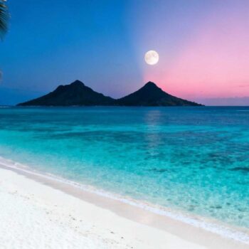 December om 14:00 bij Lanikai Beach. Parkeerboetes van € 185, zwetende toeristen die vechten om schaduw, warmtewaas die de Mokulua-eilanden vervaagt. April om 07:30 bij hetzelfde strand: kristalhelder turkoois water, poederachtig wit zand zonder voetafdrukken, dramatische maanopgang tussen de eilanden. Het geheim dat 88% van Lanikai-bezoekers mist: het 8-maanden venster van april tot november transformeert dit Hawaiiaanse paradijs van overvolle toeristenval naar authentieke lokale ervaring. December's drukte vs april's stilte: het 8-maanden venster Het hoogseizoen-paradox van Lanikai onthult zich in pure cijfers. December tot april brengt 35.000 jaarlijkse Waikiki-bezoekers die het "geheime" strand ontdekken. Accommodaties in nabijgelegen Kailua kosten € 275 per nacht. Parkeerboetes van $ 200 (€ 185) sinds juli 2014 wachten op onwetende bezoekers. Mokulua Drive wordt een bumperkleef-zone van verhuurde auto's. April tot november draait dit scenario om. Kailua-accommodaties zakken naar € 120 per nacht - een besparing van € 155. Perfecte temperaturen van 26-29°C blijven identiek aan het hoogseizoen. September-oktober registreren de minste drukte, terwijl weercondities optimaal blijven. Grace Bay's mei-september geheim toont hetzelfde patroon voor premium strandbestemmingen. Wat april-november echt onthullen aan Lanikai Buiten het hoogseizoen onthult Lanikai zijn werkelijke magie. De windwaardse positie van Oahu creëert unieke natuurfenomenen die massatoerisme overspoelt. Maanopkomst-magie boven de Mokulua-eilanden De volle maan die opkomt tussen de Na Mokulua-eilanden gebeurt tijdens specifieke perioden per jaar. September en oktober bieden de helderste lucht voor dit fenomeen. Zonsopgang verschijnt rechtstreeks tussen beide eilanden tijdens herfstmaanden. Een lokale fotograaf die al tien jaar dit fenomeen vastlegt, verklaart: "Tussen april en november heb je 25-30 meter zichtbaarheid voor deze shots. In het hoogseizoen daalt dit naar 15-20 meter door wind en drukte." Het parkeer-geheim dat locals kennen Kailua Beach Park ligt 1,2 km van Lanikai - een 15 minuten wandeling die € 185 boetes voorkomt. Locals fietsen vanaf Kalapawai Market, een 10 minuten ritje door residentiële wijken. April-november bezetting: 60-70% 's ochtends. December-april: 95-100% bezetting voor 09:00. Samoa's toegangsysteem toont hoe Pacific-eilanden authentieke ervaringen beschermen. Hoe je Lanikai ervaart zoals de oorspronkelijke Kaʻōhao-bewoners Het oorspronkelijke Kaʻōhao - "winderige vlakte" - onthult zich alleen buiten het hoogseizoen. Lokale rituelen worden zichtbaar zonder toeristenmassa's. Ochtend-timing: 06:30 tot 09:00 Kailua-bewoners arriveren om 07:00 voor hun ochtendroutine. SUP-verhuur kost € 35 per dag bij lokale shops, identiek aan hoogseizoen-prijzen. Kayak-tochten naar de 1,6 km verre Mokulua-eilanden duren 25-35 minuten paddelen. Wailea Point pillbox-wandeling onthult WOII-bunkers met panoramisch uitzicht. Een gids die al 15 jaar groepen begeleidt: "April-november krijg je kalme oceanen tussen mei en september. Perfect voor beginners die naar de Mokes willen peddelen." Petite Anse's timing-geheim bewijst hoe lege-strand-ervaringen universeel zijn. Poke zoals locals het eten Kalapawai Market (sinds 1932) verkoopt verse poke voor € 12, terwijl Waikiki € 22 rekent voor identieke porties. Haupia-toetje van lokale bakkerijen kost € 4 versus € 8 in toeristengebieden. Een Kailua-bewoner die al 20 jaar op het eiland woont: "Kalapawai is waar we echt eten. Dagelijks bereid met vis van lokale vissers, niet de geïmporteerde tuna die toeristen krijgen." Het kosten-verschil dat niemand verwacht De financiële realiteit verrast Nederlandse bezoekers. April-november accommodatie in Kailua: € 120 per nacht. Hoogseizoen identieke kamers: € 275. Over drie nachten betekent dit € 465 totale besparing. Kayak-verhuur blijft € 35 per dag, maar zonder wachtrijen of drie dagen vooraf reserveren. Een verhuurder verklaart: "In laagseizoen kun je nog dezelfde dag huren. December-april is alles weken van tevoren volgeboekt." Het enige verschil: crowd density, niet natuurschoonheid. Temperaturen, water clarity en snorkel-condities blijven identiek. Conchal's € 155 besparing toont dezelfde timing-economie voor tropische bestemmingen. Jouw Vragen Over Lanikai Beach, Hawaï (États-Unis) Beantwoord Is zwemmen veilig buiten hoogseizoen? April-november biedt juist stabielere oceaancondities dan winter. Golven van 0,3-0,6 meter versus 0,6-1,2 meter in hoogseizoen. Windwaardse ligging betekent consistente passaatwinden van 15-25 km/u, niet seizoensgebonden. Snorkel-zichtbaarheid: 25-30 meter versus 15-20 meter in winter. Hoe vermijd ik de € 185 parkeerboete? Parkeer bij Kailua Beach Park (GPS: 21.3915° N, 157.7447° W) en wandel 15 minuten via Mokulua Drive. Gratis parkeren met openbare voorzieningen. Alternatief: huur fiets bij Kailua-centrum voor € 25 per dag. Locals fietsen altijd - het is onderdeel van de authentieke ervaring. Verschilt Lanikai echt van Waikiki? Fundamenteel verschillende concepten. Lanikai: residentiële exclusiviteit zonder commercie, geen hotels aan strand, geen souvenirwinkels. Waikiki: 1 miljoen+ jaarlijkse bezoekers, volledige commerciële infrastructuur. Bezoekersdichtheid: Waikiki 100+ mensen per 100 meter strand, Lanikai maximaal 20-30 mensen zelfs in hoogseizoen. April-ochtend om 07:15 bij het Lanikai Monument. Opkomende zon kleurt poederachtig wit zand goudgeel. Twee Mokulua-eilanden glinsteren in turquoise water. Een paddleboarder passeert - lokale, geen toerist. Dit is Lanikai zoals bedoeld: Kaʻōhao, waar stilte de grootste luxe blijft.