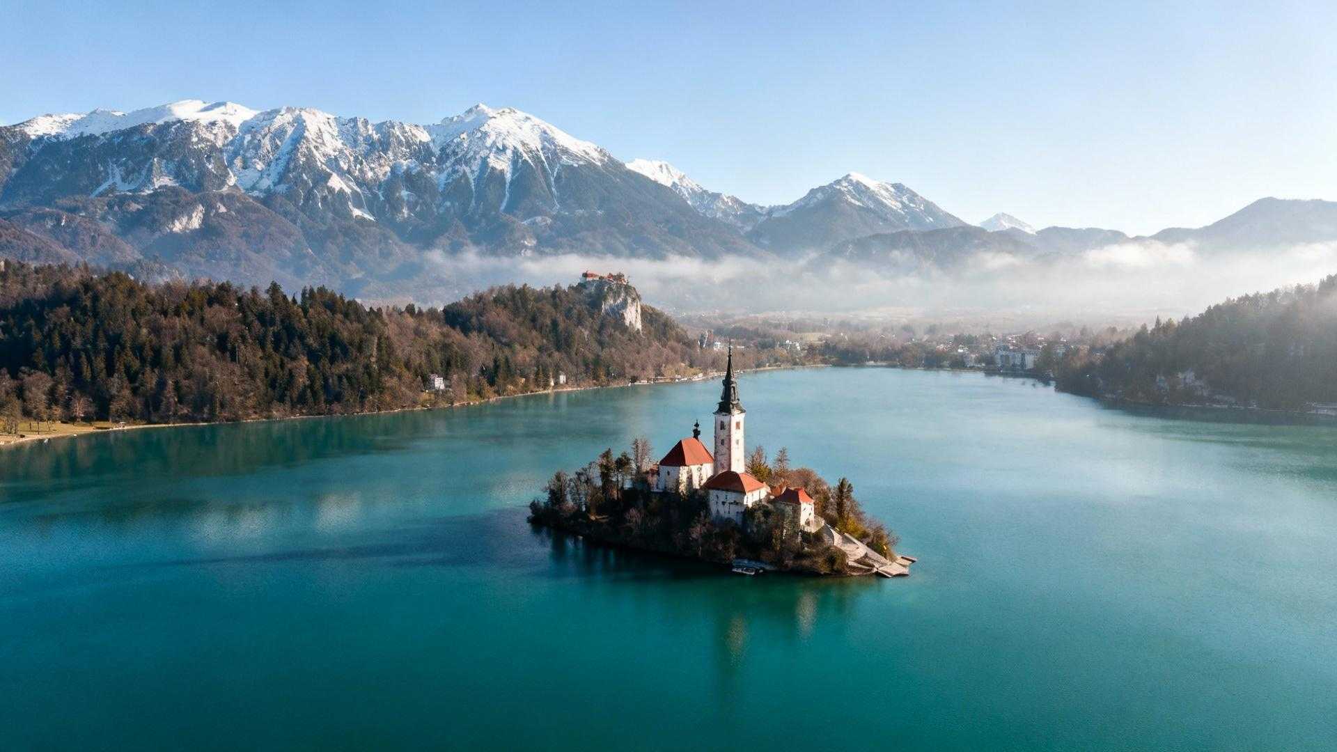 Augustus in Zermatt betekent €340 hoteltarieven en wachtrijen bij de Gornergrat-baan. Dertig miljoen bezoekers verdringen zich jaarlijks op Zwitserse bergpaden. Verschuif 1.100 km naar Ljubljana en ontdek €95 accommodatie, lege Julian Alpen-trails en slechts 5 miljoen bezoekers. Slovenië elimineert de keuze tussen Zwitserland en Oostenrijk door beide te overtreffen op authenticiteit, toegankelijkheid en waarde. Dit 20.273 km² compacte land vangt Alpenschoonheid, mediterrane kust én ondergrondse wonderen zonder de massa-toerisme premie. Wanneer Alpenschoonheid 70% goedkoper wordt zonder concessies De Julian Alpen bereiken 2.864 meter met Triglav tegenover Zwitserland's 4.478 meter Matterhorn. Het landschap voelt identiek: smaragdgroene valleien, gletsjermeren, bloeiende alpine flora. Het verschil zit in toegankelijkheid en prijs. Lake Bled ligt 54 km van Ljubljana, Postojna-grotten 50 km, Adriatische kust Piran 120 km. Zwitserland verspreidt hoogtepunten over 41.285 km² — Slovenië comprimeert vergelijkbare verscheidenheid in de helft. Accommodaties kosten €70-120 per nacht versus Interlaken €180-275. Maaltijden variëren van €10-20 versus €25-40 in Zwitserland. Nationaal park toegang kost €10-15 tegen Zwitserse €40-60. De wiskundige logica blijkt helder: 20-30% lagere kosten bij gelijke visuele impact. De geografie die twee landen combineert in één weekend Bergmajestuositeit zonder Zwitserse prijsschok Triglav National Park (880 km²) weerspiegelt Zwitserse Alpenesthetiek met turquoise Soča rivier en verticale bergwanden. Gentiaanvelden bloeien mei tot september tussen kristalheldere bergbeken. Vogel Ski Resort op 1.535 meter biedt wintersporten voor €35 dagpas versus Zermatt €80. De 54 km afstand tussen Bled en Bohinj creëert variatie zonder logistieke hoofdpijn. Beide meren liggen op 30 minuten rijden en bieden identieke postkaartperfectie als Zwitserse concurrenten. Mediterrane kust die Oostenrijk mist Piran's 46 km Adriatische kustlijn transformeert Slovenië van puur Alpenland naar hybride bestemming. Venetiaanse architectuur stamt uit de 13e eeuw. Verse zeevruchten kosten €12-18 versus €30+ in Zürich restaurants. Zonnige 28°C zomers combineren bergfrisse ochtenden met mediterrane middagen. Deze geografische bonus — bergen én zee binnen 2 uur rijden — overtreeft beide buurlanden afzonderlijk. Geen andere Alpenbestemming biedt deze verscheidenheid binnen zo'n compact gebied. Wat 2,1 miljoen locals dagelijks ervaren dat 88% bezoekers mist Duurzaamheidsmodel als cultureel DNA Slovenië's Green Scheme certificeert sinds 2016 meer dan 60 bestemmingen op milieu-impact. Locals fietsen door Ljubljana via 176 km gratis fietsnetwerk sinds 2011. Het land beschermt 53% natuurgebieden en beperkt toeristengroepen tot 25 personen in Postojna-grotten. Dit weerspiegelt nationale identiteit sinds 1991 onafhankelijkheid, geen marketing-truuk. Vergelijk met Zwitserland's commercialisering van Jungfraujoch waar treinkaartjes €200 kosten. Zoals Eva Marolt van VVV Tourism Slovenia bevestigt: "Met 9% groei in toerisme laat Slovenië zien dat duurzaam reizen samengaat met economische groei." Culinaire fusie die alpine traditie ontmoet Kranjska klobasa (Sloveense worst sinds 1896) en žlikrofi (gevulde deeg uit Idrija, UNESCO sinds 2022) definiëren lokale keuken. Rebula en Teran wijnen kosten €3-8 per glas in lokale kroegen. De combinatie van Oostenrijkse hartigheid, Italiaanse finesse en Balkaanse smaakprofielen creëert unieke gastronomie. Ljubljana's Odprta Kuhna markt opent elke vrijdag maart tot oktober. Vijftig kraampjes serveren gerechten van €5-12 zonder toeristische prijsopslag. Ana Novak, eigenaar eco-lodge Bled, legt uit: "Gasten waarderen de rust en natuurbehoud, iets dat andere Alpengebieden snel verliezen." Waarom mei-september Slovenië's bezoekers slim verspreiden Beste bezoektijd loopt mei tot september met 20-30°C temperaturen. Bloeiende Alpen, zwembaar Bled juni-augustus, perfecte Adriatische kust juli-september. Juli markeert hoogseizoen maar drukte blijft relatief: 5 miljoen jaarlijks versus Zwitserland 30 miljoen betekent 83% minder mensenmassa's. November-maart vormt laag seizoen met wintersporten december-maart in 7 skigebieden. Schengen-lidmaatschap sinds 2023 elimineert grenscontroles en nieuwe treinverbinding Innsbruck-Ljubljana verbetert bereikbaarheid verder in 2025. Vliegen Amsterdam-Ljubljana duurt 1,5-2 uur voor €150-250 retour. Geen vignet nodig zoals Zwitserland's €43,35 verplichte snelwegpas. Jouw vragen over waarom Slovenië het nieuwe Zwitserland is beantwoord Welk accommodatiebudget moet ik verwachten vergeleken met Zwitserland? Laag segment hostels en guesthouses kosten €30-50 versus Zwitserland €60-90. Middenklasse 3-sterren hotels variëren €70-120 versus €150-250. Hoog segment 4-5 sterren resorts €150-300+ versus €400-600+. Gemiddelde besparing bedraagt 40-50% bij vergelijkbare kwaliteit en service. Hoe beweeg ik tussen hoogtepunten zonder auto? Ljubljana-Bled bus kost €6 voor 1 uur 20 minuten. Ljubljana-Postojna bus €7 voor 1 uur. Ljubljana-Piran bus €12 voor 2,5 uur. Trein Ljubljana-Maribor kost €9. Autohuur varieert €35-50 per dag voor maximale flexibiliteit tussen bestemmingen. Waarom spreekt niemand over Slovenië zoals over Zwitserland? Marketing-budget verschil verklaart alles: Zwitserland besteedt €100+ miljoen jaarlijks, Slovenië €15 miljoen. Onafhankelijkheid sinds 1991 betekent jonge toerisme-infrastructuur. Resultaat blijft authentiek, niet-gecommercialiseerd alternatief voor wie tijdig ontdekt. Luka Petric van Reizen Magazine bevestigt: "Slovenië voelt als compacte Zwitserland met minder drukte en vriendelijkere prijzen." Eerste ochtendlicht kleurt Lake Bled's 15e-eeuwse kerkje goud terwijl mist tussen Julian Alpen danst. Twee lokale vissers sorteren vangst zonder toeristen in zicht. Dit blijft Slovenië's timing-geheim: arriveer vroeg, reis mei-juni, ontdek wat 83% minder bezoekers betekent voor Alpenschoonheid die voelt als privilege.